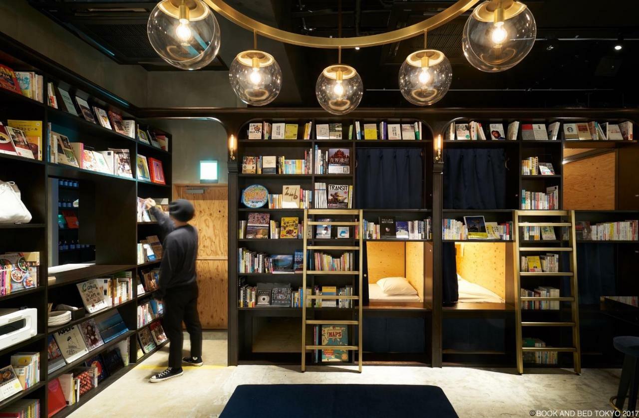 Sleeping berths set into a tall wall of filled bookshelves