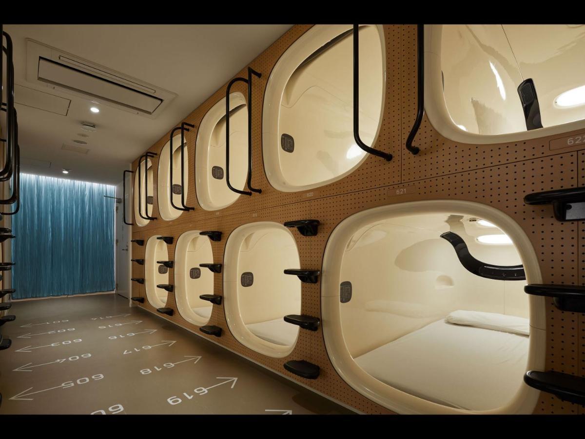 Moulded white sleeping pods stacked in two tiers under even light