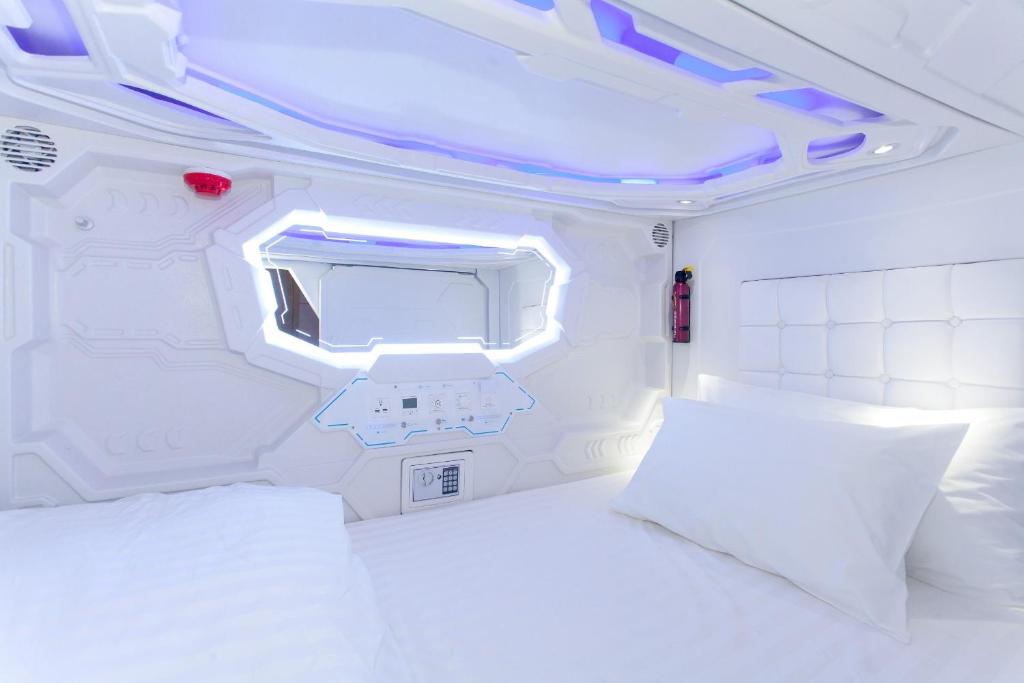 A corridor of stacked sleeping berths lit by low strip lighting