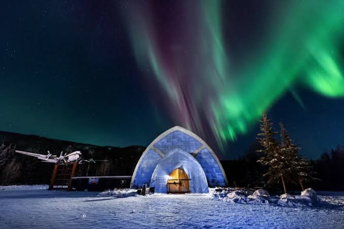 Carved ice columns and seating under coloured light